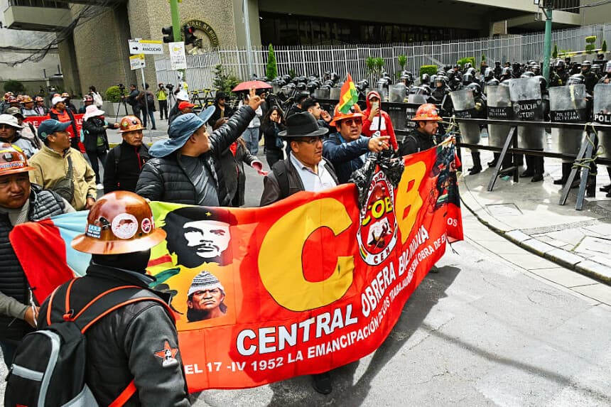 Manifestantes pasan junto a la policía antidisturbios durante una marcha en la que se pedía la renuncia del presidente Rodrigo Paz, en La Paz, el 22 de mayo de 2026. (AIZAR RALDES / AFP vía Getty Images)