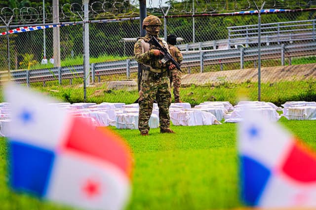 Un oficial del Servicio Aeronaval de Panamá vigila 12 toneladas de cocaína divididas en cientos de paquetes en la sede del Servicio Aeronaval en la ciudad de Panamá, el 11 de noviembre de 2025.  (MARTIN BERNETTI/AFP vía Getty Images)