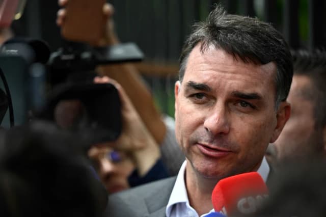 El senador Flávio Bolsonaro, hijo del expresidente brasileño Jair Bolsonaro, habla con los periodistas tras salir de la sede de la Policía Federal donde su padre se encuentra detenido en Brasilia, el 9 de diciembre de 2025. (Ton MOLINA/AFP vía Getty Images)