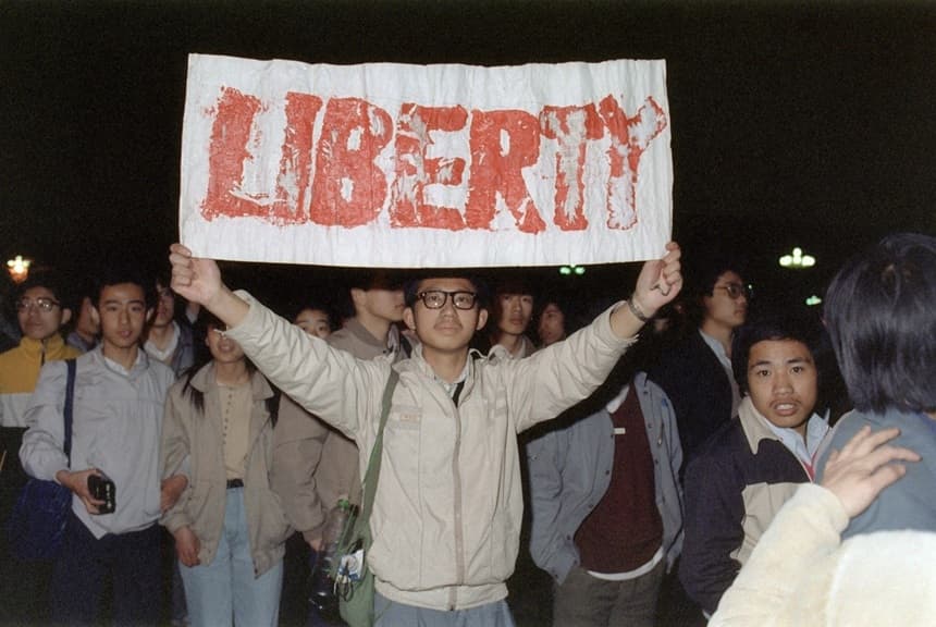Un estudiante muestra una pancarta con uno de los lemas coreados por la multitud de unas 200,000 personas que se congregaron en la plaza de Tiananmen, en Beijing, el 22 de abril de 1989. (Catherine Henriette /AFP/Getty Images)
