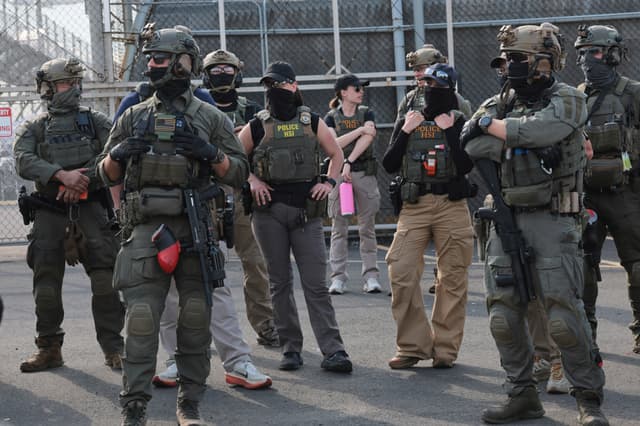 Agentes de Investigaciones de Seguridad Nacional (HSI) montan guardia frente a los manifestantes que se encuentran frente al Delaney Hall, edificio que se utiliza como centro de detención del Servicio de Inmigración y Control de Aduanas, el 29 de mayo de 2026 en Newark, Nueva Jersey. (Michael M. Santiago/Getty Images)