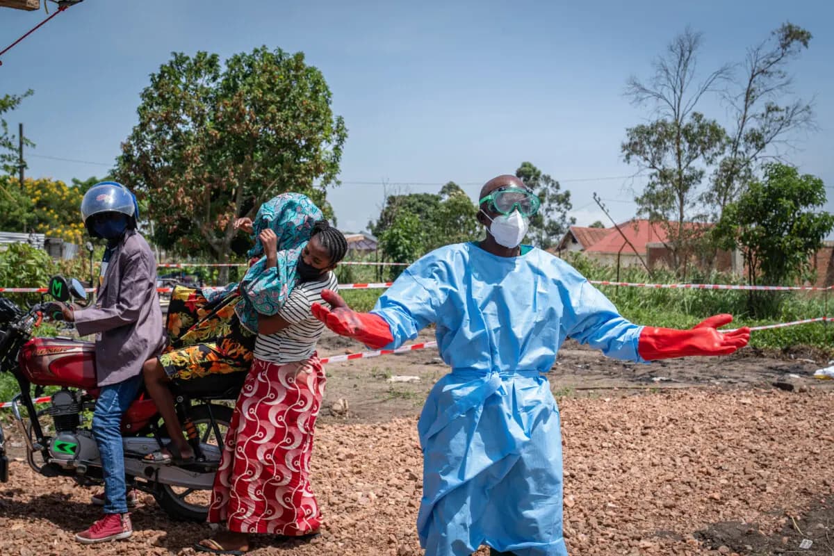 <em>Un trabajador sanitario hace un gesto mientras pide ayuda para trasladar a un paciente (segundo por la izquierda) con sospecha de ébola, que fue llevado en mototaxi al hospital de Rwampara en Ituri, al este del Congo, el 26 de mayo de 2026. (Glody Murhabazi/AFP vía Getty Images).</em>