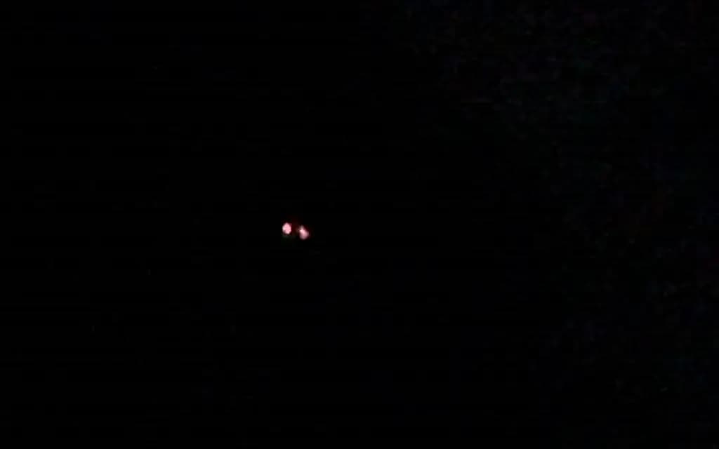 En marzo de 2022, en el noreste de Estados Unidos, un testigo observó dos fuentes de luz de color rojo brillante flotando cerca del horizonte a una distancia estimada de 2.500 pies. Esta es una captura de pantalla del video personal del testigo. (Captura de pantalla vía The Epoch Times/Cortesía del Pentágono)