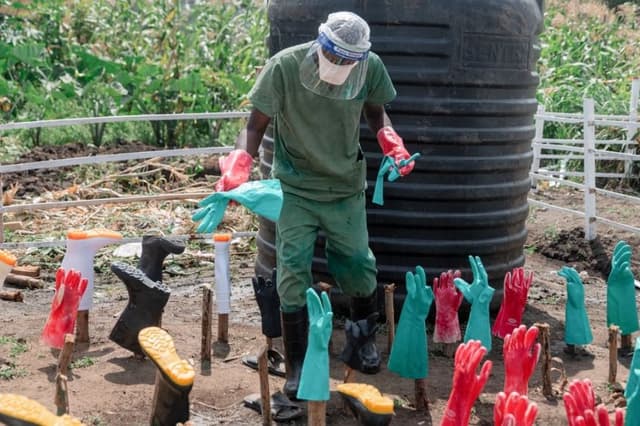 El personal de limpieza lava botas y guantes reutilizables, desinfecta equipos y mantiene las áreas comunes en el centro de tratamiento de Ébola del Hospital General de Referencia de Rwampara, en Rwampara, Congo, el 12 de junio de 2026. (Jospin Mwisha/AFP vía Getty Images)