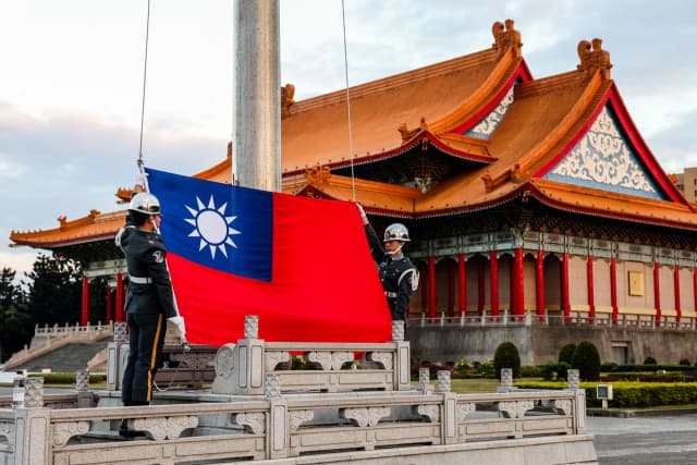 Guardias izan la bandera nacional de Taiwán en el Bulevar de la Democracia, en el Salón Conmemorativo de Chiang Kai-shek en Taipéi, el 29 de noviembre de 2024. (I-Hwa Cheng/AFP vía Getty Images).