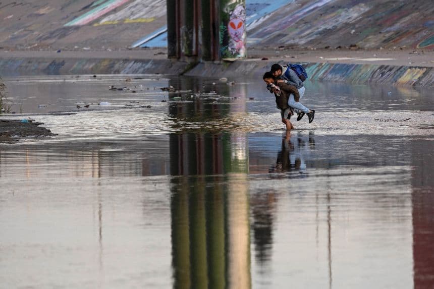 Un traficante transporta a un migrante a través del Río Grande cerca de una zona fronteriza de alto tráfico en El Paso, Texas, el 20 de diciembre de 2022, visto desde Ciudad Juárez, México.  (John Moore/Getty Images)