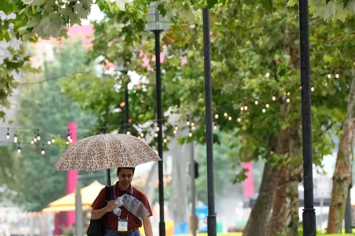 Un asistente a la convención camina bajo la lluvia frente al Centro de Convenciones George R. Brown el 17 de junio de 2026, en Houston, Texas. (Kevin M. Cox/AP Photo)