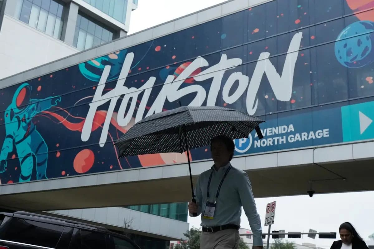 Un asistente a la convención camina bajo la lluvia frente al Centro de Convenciones George R. Brown en Houston, Texas, el 17 de junio de 2026. (Kevin M. Cox/AP Photo)