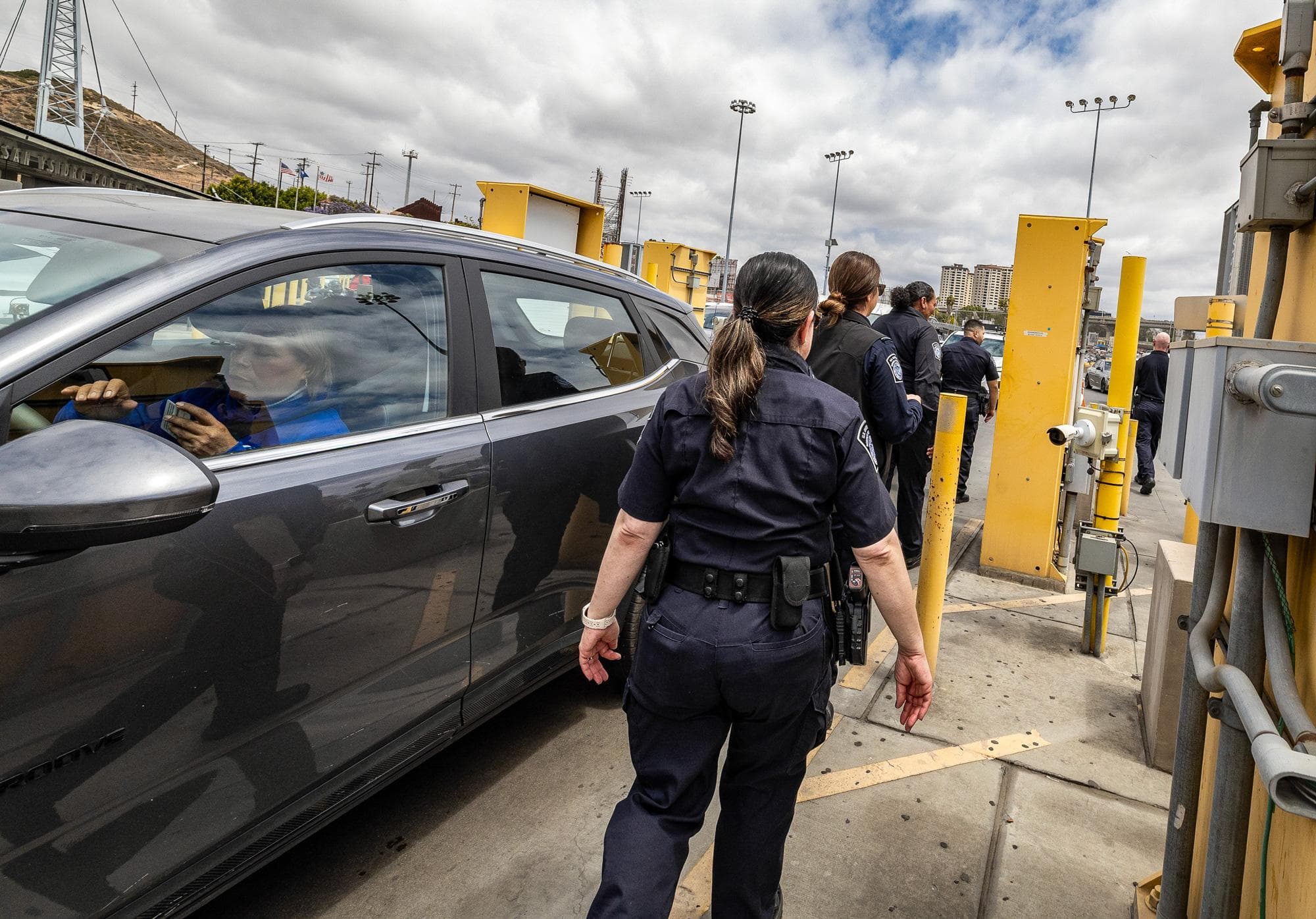 Agentes de la Oficina de Aduanas y Protección Fronteriza de EE. UU. caminan por la entrada para vehículos del puesto fronterizo de San Ysidro, cerca de San Diego, el 26 de mayo de 2026. (John Fredricks/The Epoch Times).