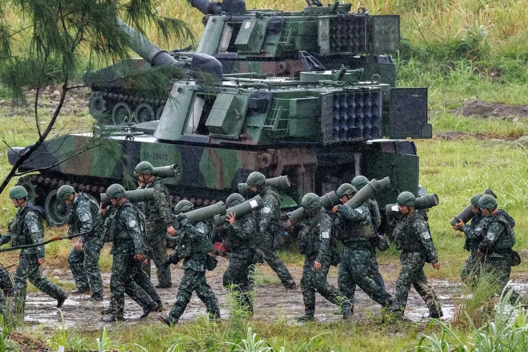 Soldados taiwaneses transportan proyectiles de artillería para un obús autopropulsado M109A2 durante un ejercicio de entrenamiento con fuego real en Taichung el 9 de junio de 2026. Para 2030, el presidente de Taiwán, Lai Ching-te, quiere aumentar el presupuesto militar del país del 3 % actual al 5 % del PIB. (Cheng Yu-chen / AFP vía Getty Images)