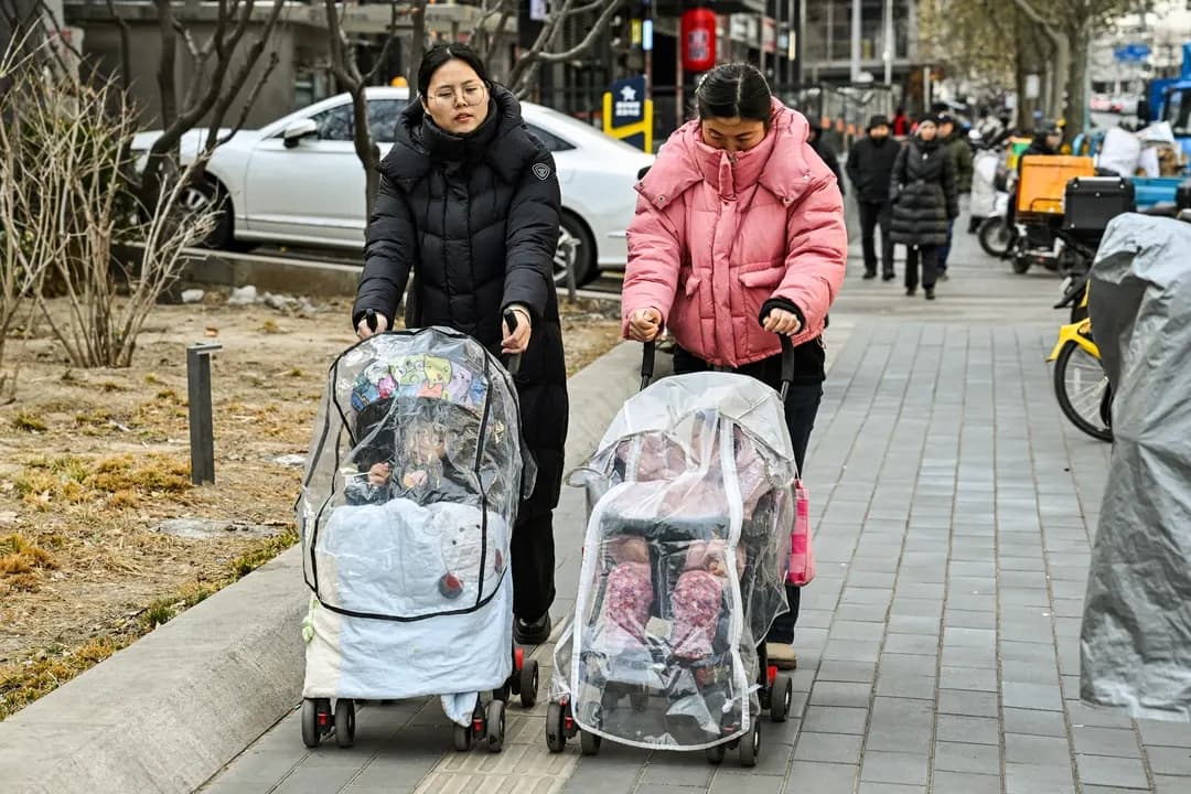 Unas mujeres empujan cochecitos por una calle de Beijing el 4 de enero de 2026. El número de nacimientos en China en 2025 alcanzó un mínimo histórico, mientras que la proporción de adultos de 60 años o más llegó a alrededor del 23 por ciento. (Adek Berry / AFP vía Getty Images}
