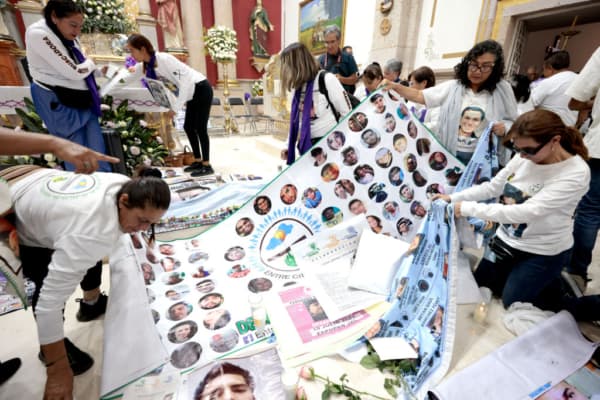 <em>En una iglesia se exhiben imágenes de personas desaparecidas durante una jornada de oración en Teuchitlán, estado de Jalisco, México, el 16 de marzo de 2025. Los participantes marcharon para exigir justicia tras el macabro hallazgo de restos óseos calcinados, zapatos y prendas de vestir en un presunto centro de adiestramiento de un cártel del narcotráfico. (Ulises Ruiz / AFP vía Getty Images)</em>