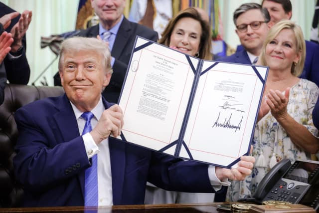 El presidente Donald Trump muestra la Ley de Seguridad en Estados Unidos firmada en el Despacho Oval el 10 de junio de 2026. (Alex Wong/Getty Images)