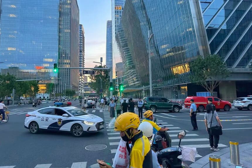 La foto muestra a la policía en máxima alerta tras el impacto de una pequeña aeronave en la Torre CITIC el 26 de junio de 2026. (Peter Catterall/AFP).