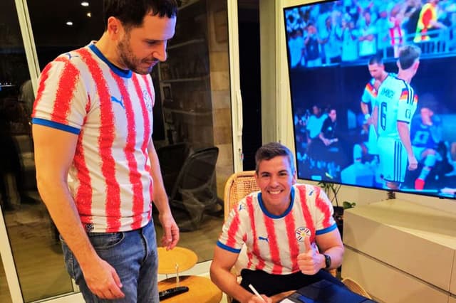 Fotografía difundida en la cuenta en X @SantiPenap del presidente de Paraguay, Santiago Peña (d), firmando el decreto N.º 6280 que declara feriado nacional el martes 30 de junio para celebrar la clasificación de la selección a los octavos de final del Mundial de la FIFA 2026 tras vencer a Alemania. EFE/ @SantiPenap 