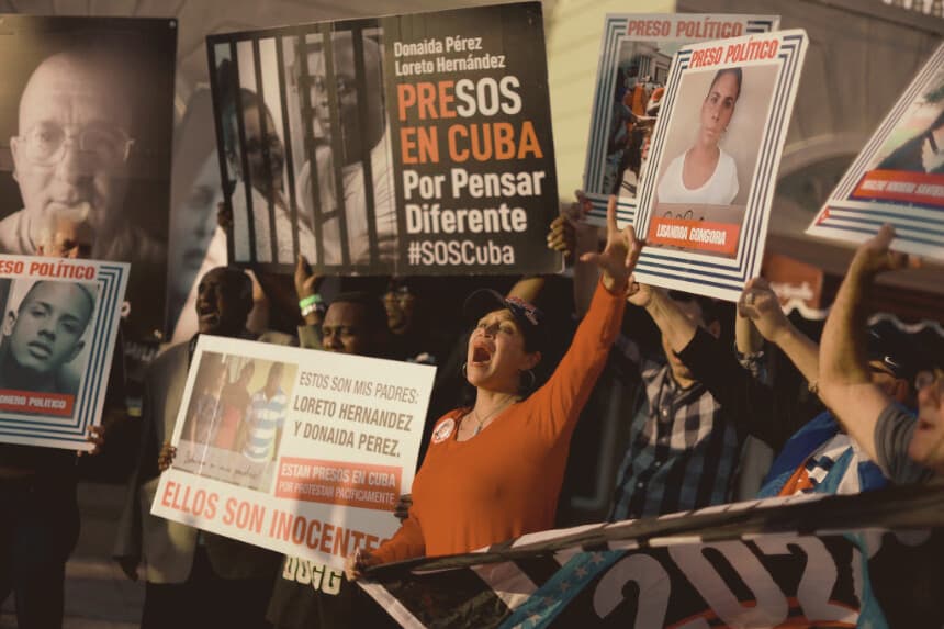Varias personas sostienen fotografías de presos políticos recluidos en cárceles cubanas, el 18 de marzo de 2024, en Miami, Florida. (Joe Raedle/Getty Images)