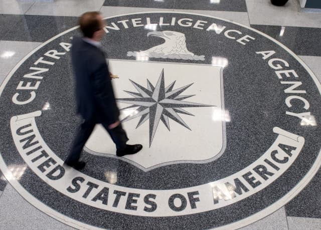 Un hombre cruza el escudo de la Agencia Central de Inteligencia (CIA) en el vestíbulo de la sede de la CIA en Langley, Virginia, el 14 de agosto de 2008. (Saul Loeb/AFP vía Getty Images).