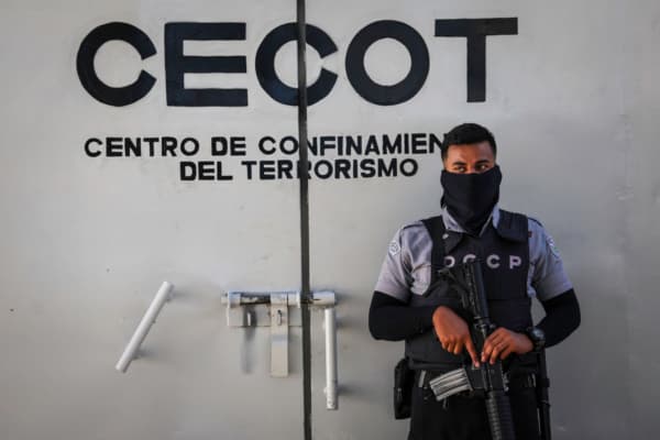 <em>Un guardia penitenciario vigila el perímetro interior del CECOT (Centro de Confinamiento del Terrorismo), donde permanecen encarcelados miles de presuntos pandilleros, el 15 de diciembre de 2025, en Tecoluca, El Salvador. El CECOT ganó notoriedad en 2025, cuando la Administración Trump comenzó su controvertida política de deportar a El Salvador a personas que afirmaba eran miembros de la organización criminal venezolana Tren de Aragua y de la Mara Salvatrucha (MS-13), una pandilla cuyos integrantes han sido históricamente salvadoreños. (John Moore/Getty Images)</em>