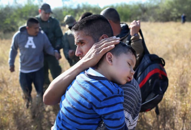 Imagen ilustrativa: Un padre sostiene a su hijo dormido, de 3 años, después de que ellos y otros inmigrantes ilegales fueran detenidos por agentes de la Patrulla Fronteriza el 7 de diciembre de 2015, cerca de Rio Grande City, Texas. (John Moore/Getty Images)