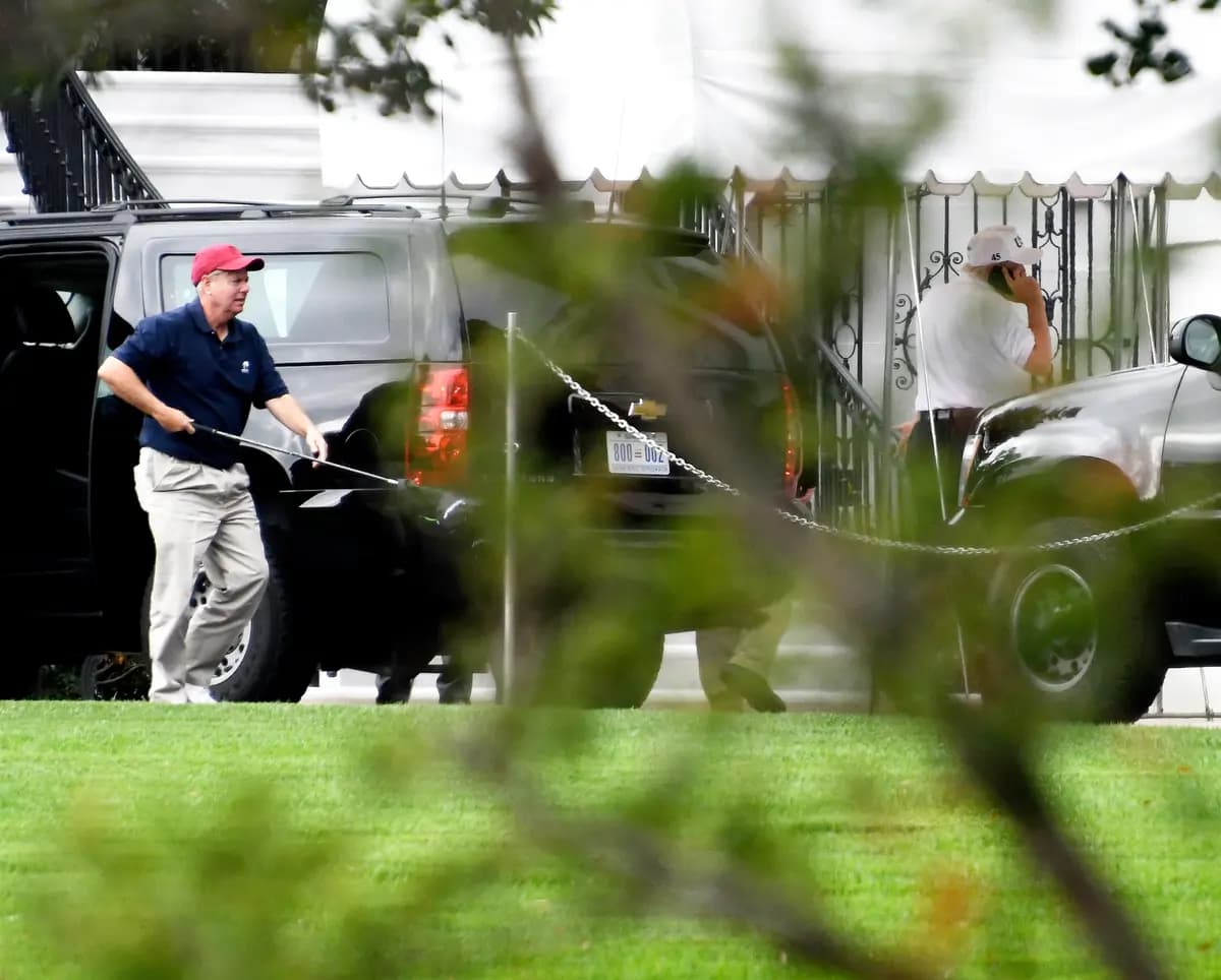 El senador Lindsey Graham (R-S.C.) (izquierda) lleva uno de sus palos de golf al salir de la limusina presidencial en la Casa Blanca el 14 de octubre de 2017. (Ron Sachs - Pool/Getty Images)