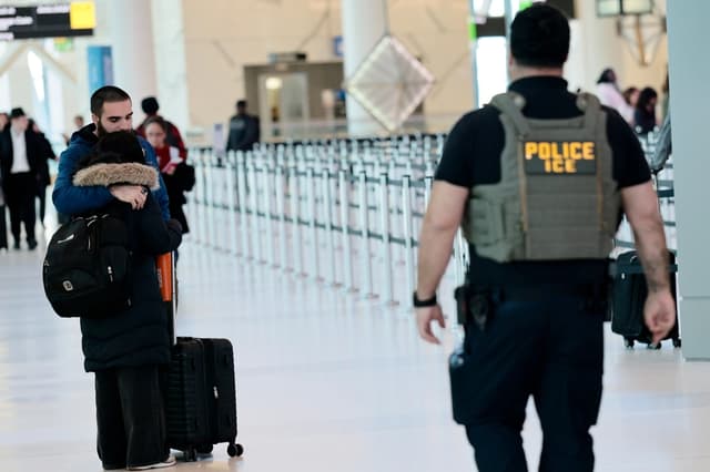 Una pareja se abraza mientras agentes del Servicio de Inmigración y Control de Aduanas (ICE) patrullan la Terminal C del Aeropuerto LaGuardia en Nueva York el 24 de marzo de 2026. (Michael M. Santiago/Getty Images)
