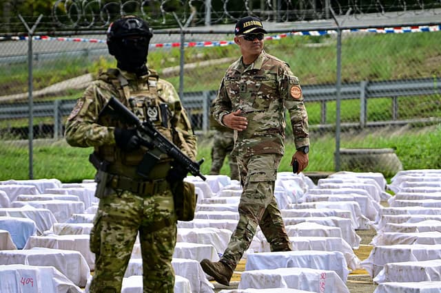 Agentes del Servicio Nacional Aeronaval de Panamá custodian 12 toneladas de cocaína repartidas en cientos de paquetes en la sede del Servicio Aeronaval, en la ciudad de Panamá, el 11 de noviembre de 2025. (MARTIN BERNETTI/AFP vía Getty Images)