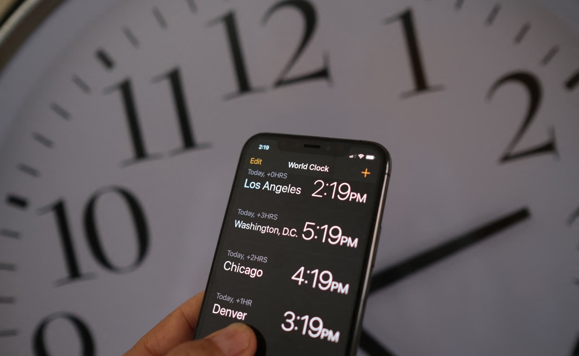 Un reloj detrás de un teléfono inteligente que muestra la hora tras la implementación del horario de verano en Los Ángeles el 15 de marzo de 2022. (Chris Delmas/AFP vía Getty Images)
