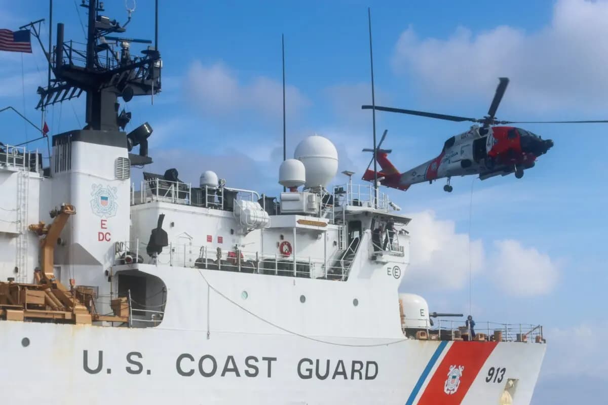 La tripulación del buque Mohawk (WMEC 913) de la Guardia Costera de EE. UU. y la tripulación de vuelo de un helicóptero MH-60 Jayhawk de la Guardia Costera realizan maniobras de entrenamiento en el mar del Caribe el 15 de julio de 2025. (Marinero Corrie Gill/Guardia Costera de EE. UU.).