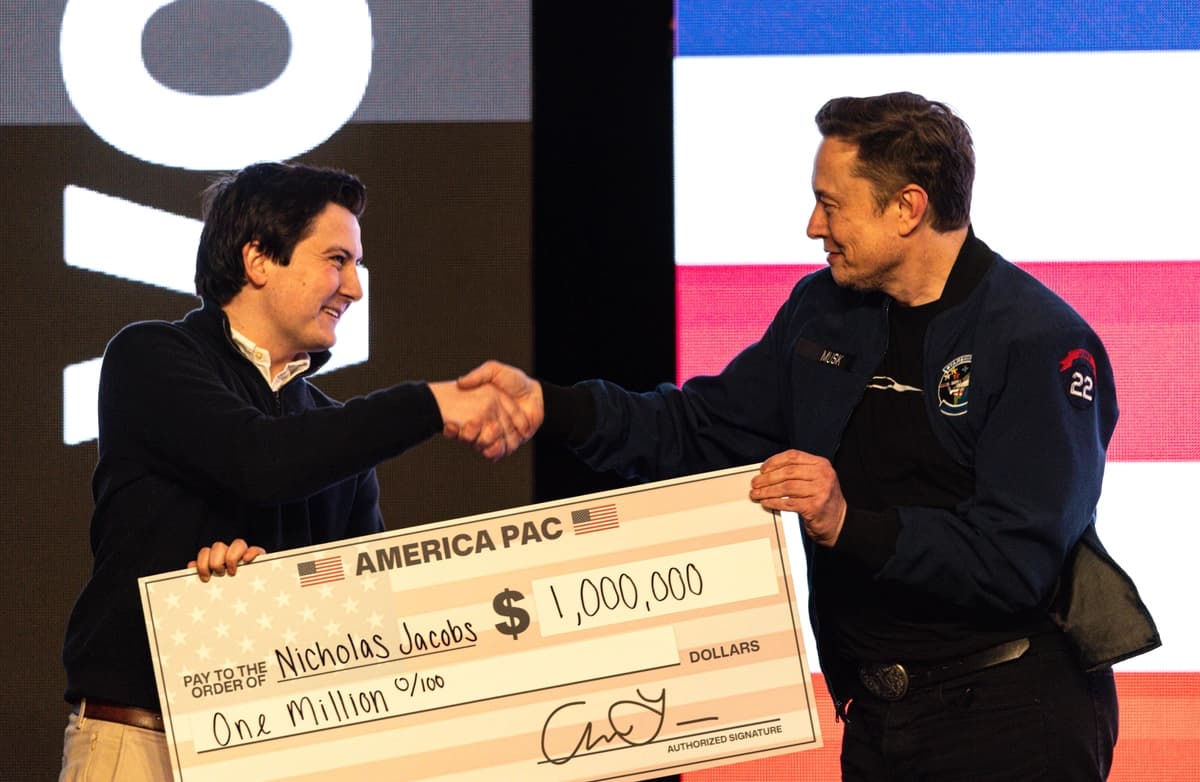 Elon Musk entrega un cheque de un millón de dólares a Nicholas Jacobs durante un encuentro público en Green Bay, Wisconsin, el 30 de marzo de 2025. (Jeffrey Phelps/AP Photo)
