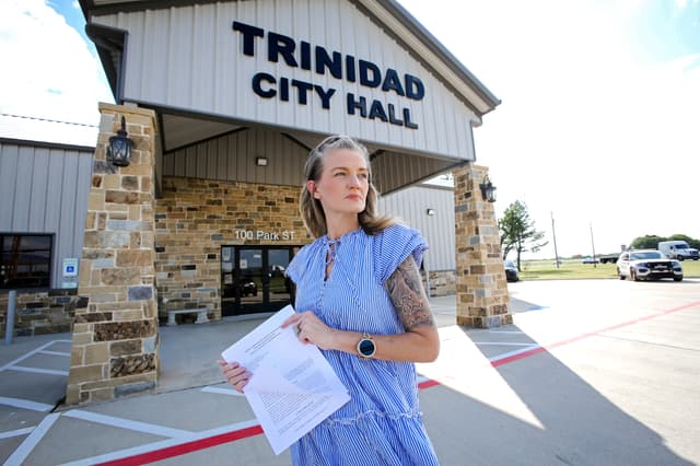 Jennifer Combs se encuentra frente al Ayuntamiento de Trinidad, en Trinidad, Texas, el 26 de junio de 2026. Es una de las varias personas que han demandado a la ciudad, alegando que se violaron sus derechos civiles. Bobby Sánchez para The Epoch Times