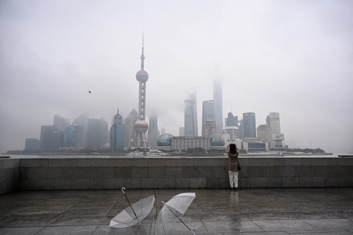 Una mujer toma una fotografía del distrito financiero de Lujiazui al otro lado del río Huangpu, en el paseo marítimo del Bund en Shanghái, China, el 5 de marzo de 2026. (Jade Gao/AFP vía Getty Images).