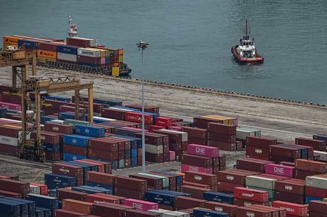 En la imagen se observa un remolcador junto a contenedores de carga en Singapur el 1 de junio de 2026. (Jam STA ROSA / AFP vía Getty Images)
