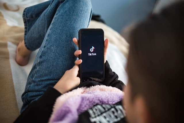 Un niño con el celular en las manos mira la pantalla. (Shutterstock)
