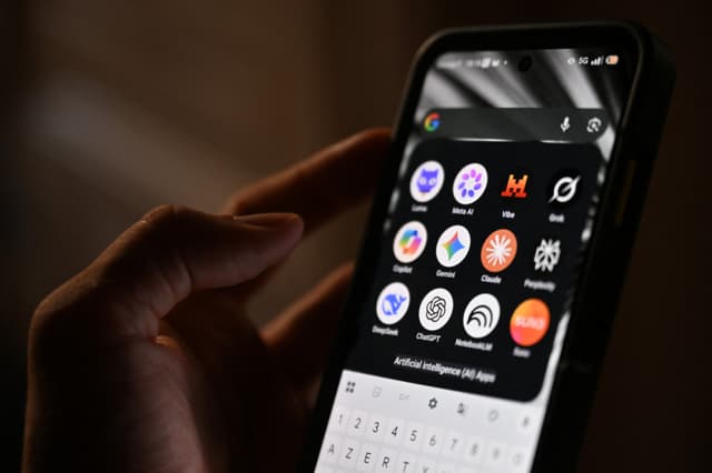 Esta fotografía muestra un teléfono inteligente sostenido en la mano que exhibe los íconos de algunas de las principales aplicaciones basadas en inteligencia artificial. (Martin LELIEVRE / AFP via Getty Images)