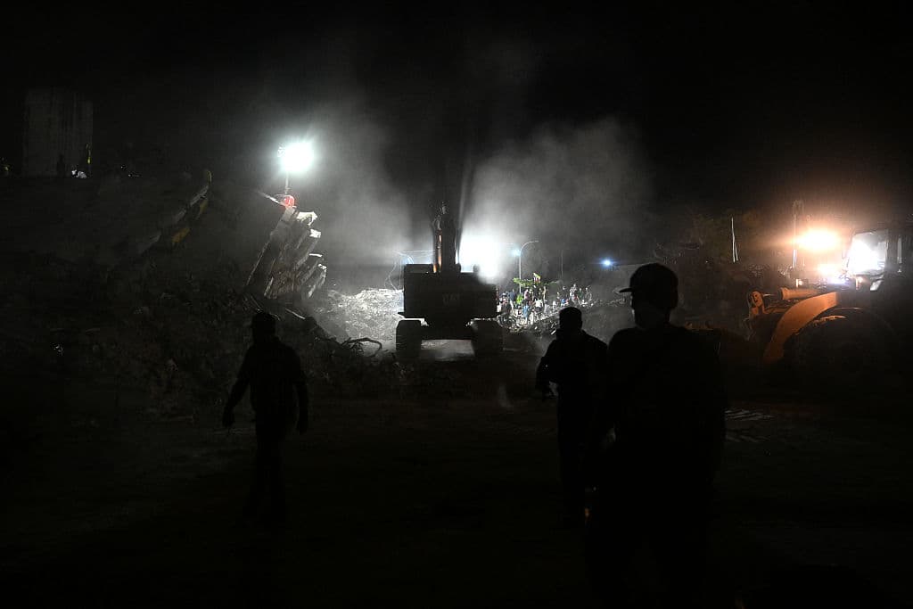 <em>Personas y equipos de rescate buscan cuerpos entre los escombros de edificios derrumbados en Caraballeda, estado de La Guaira, Venezuela, el 30 de julio de 2026. El 30 de julio de 2026, las autoridades venezolanas comenzaron a demoler edificios en el estado de La Guaira, la región más afectada por los dos terremotos del mes pasado, observó AFP. (BARRETO/AFP vía Getty Images)</em>