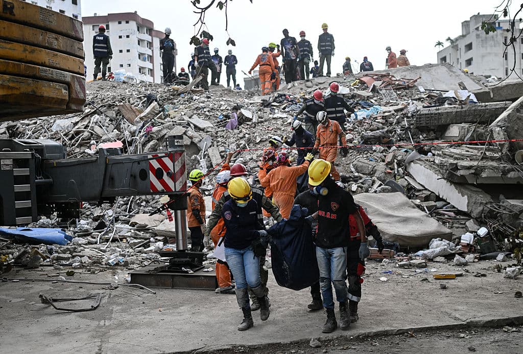 <em>Miembros del equipo de búsqueda y rescate de Argentina y voluntarios cargan cuerpos recuperados de los escombros de un edificio en Punta Tanaguanera, La Guaira, Venezuela, el 21 de julio de 2026, casi un mes después de los terremotos del 24 de junio. (Juan BARRETO/AFP vía Getty Images)</em>