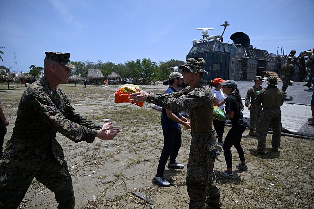 <em>Soldados estadounidenses y miembros de la Misión Ambiental Mundial (GEM) manipulan sacos de arroz para cargarlos en un camión en Catia La Mar, Venezuela, el 14 de julio de 2026, tras dos terremotos que azotaron la región. (Federico PARRA/AFP vía Getty Images)</em>