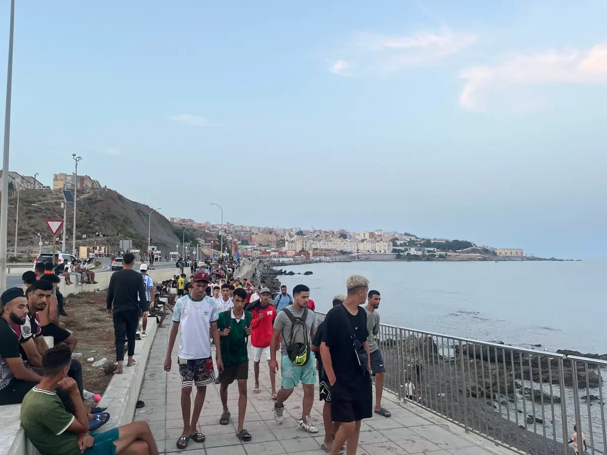 Migrantes marroquíes caminan por la Avenida Martínez Catena en Ceuta hacia la zona fronteriza el 31 de julio de 2026, a las 9:34 p. m. hora local. (Etienne Fauchaire/The Epoch Times)