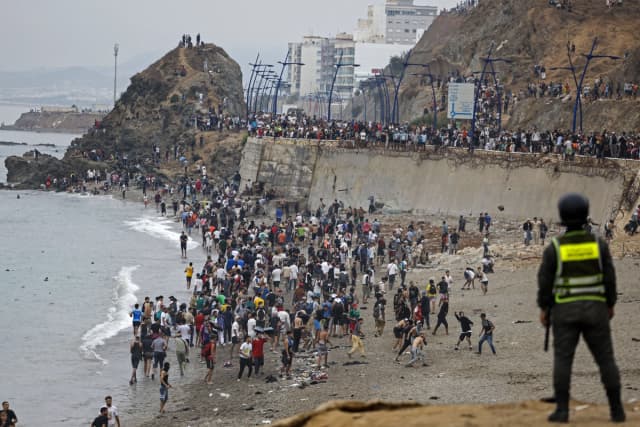 Inmigrantes ilegales se congregan junto a la valla en el lugar de los enfrentamientos cerca de Fnideq, en la frontera entre Marruecos y España, en Fnideq, Marruecos, el 31 de julio de 2026. Miles de inmigrantes cruzaron durante la noche desde Marruecos al enclave español de Ceuta, en el norte de África, según una fuente policial, y se reportaron 18 personas muertas mientras intentaban llegar al enclave. (Abdel Majid Bziouat/AFP vía Getty Images).