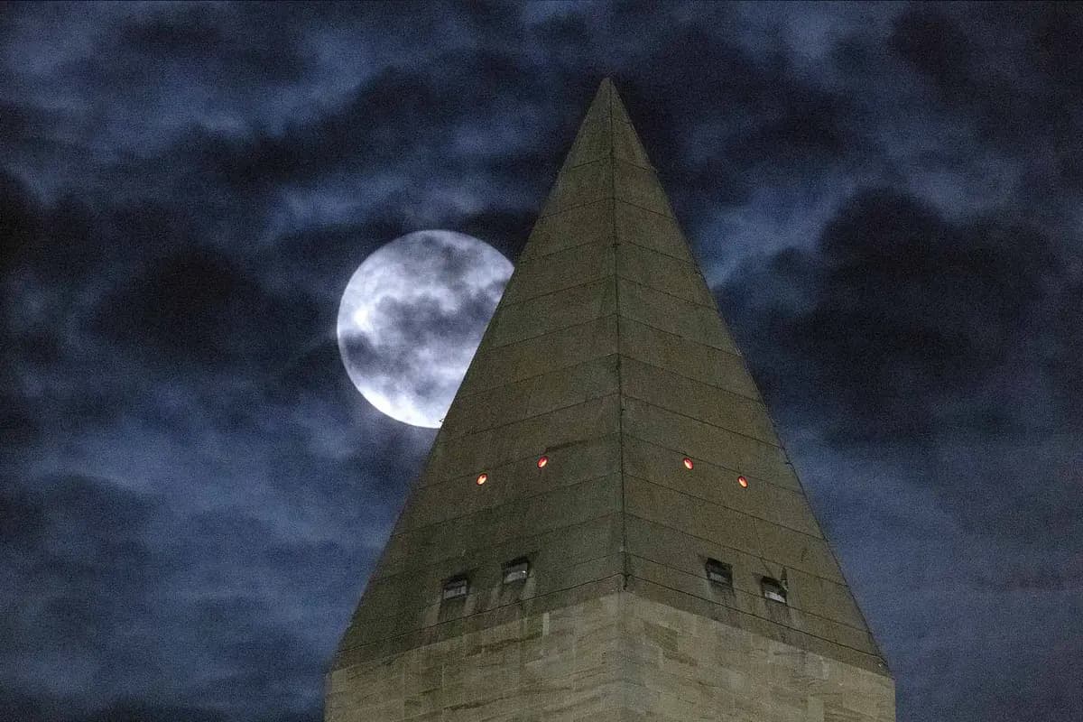 Una Luna del Esturión oscurecida por las nubes detrás del Monumento a Washington en Washington, D.C. (Somodevilla/Getty Images)