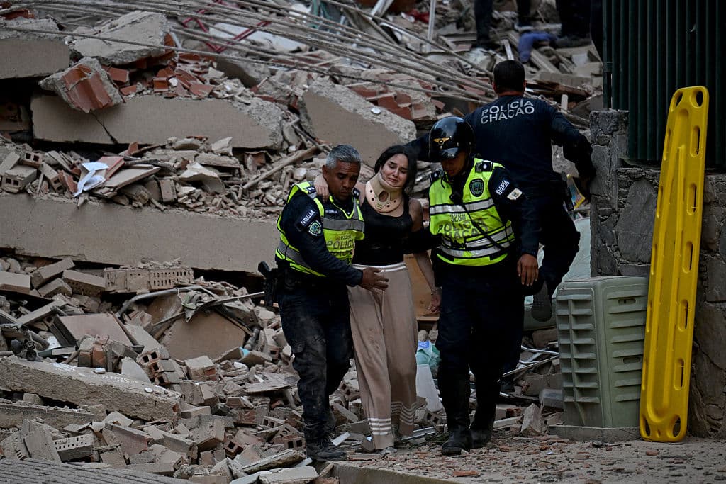 <em>La policía municipal evacua a una víctima herida de un edificio derrumbado tras un terremoto en Caracas el 24 de junio de 2026. (Juan BARRETO/AFP vía Getty Images)</em>