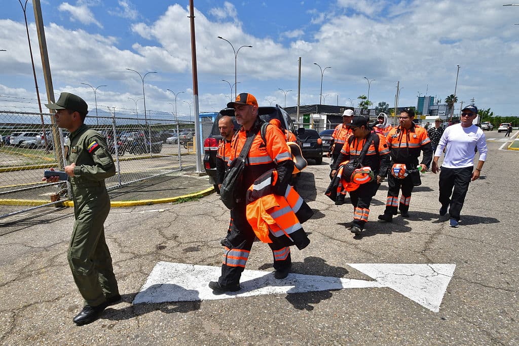 <em>Miembros del equipo de rescate mexicano Topos llegan al aeropuerto internacional Arturo Michelena en Valencia, estado Carabobo, Venezuela, para participar en las operaciones de búsqueda tras los dos terremotos, el 27 de junio de 2026. (Jacinto OLIVEROS / AFP vía Getty Images)</em>