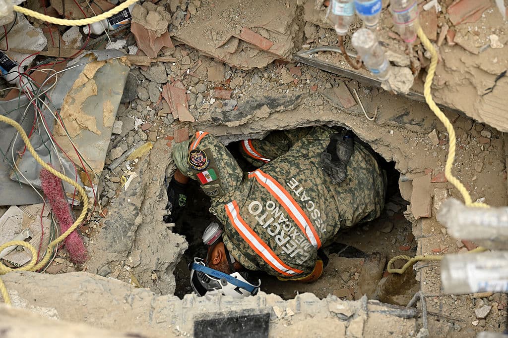 <em>Un miembro de una unidad de rescate del Ejército mexicano ingresa a un hueco entre los escombros mientras busca sobrevivientes en Caraballeda, estado de La Guaira, Venezuela, el 3 de julio de 2026. (MARTIN BERNETTI / AFP vía Getty Images)</em>