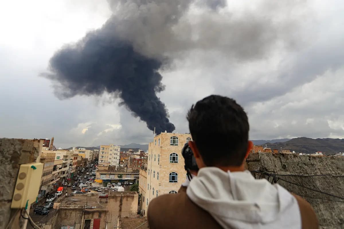 Un fotoperiodista toma una foto del humo tras un ataque aéreo israelí contra Saná, la capital de Yemen controlada por los hutíes, el 24 de agosto de 2025. (Mohammed Huwais/AFP vía Getty Images)