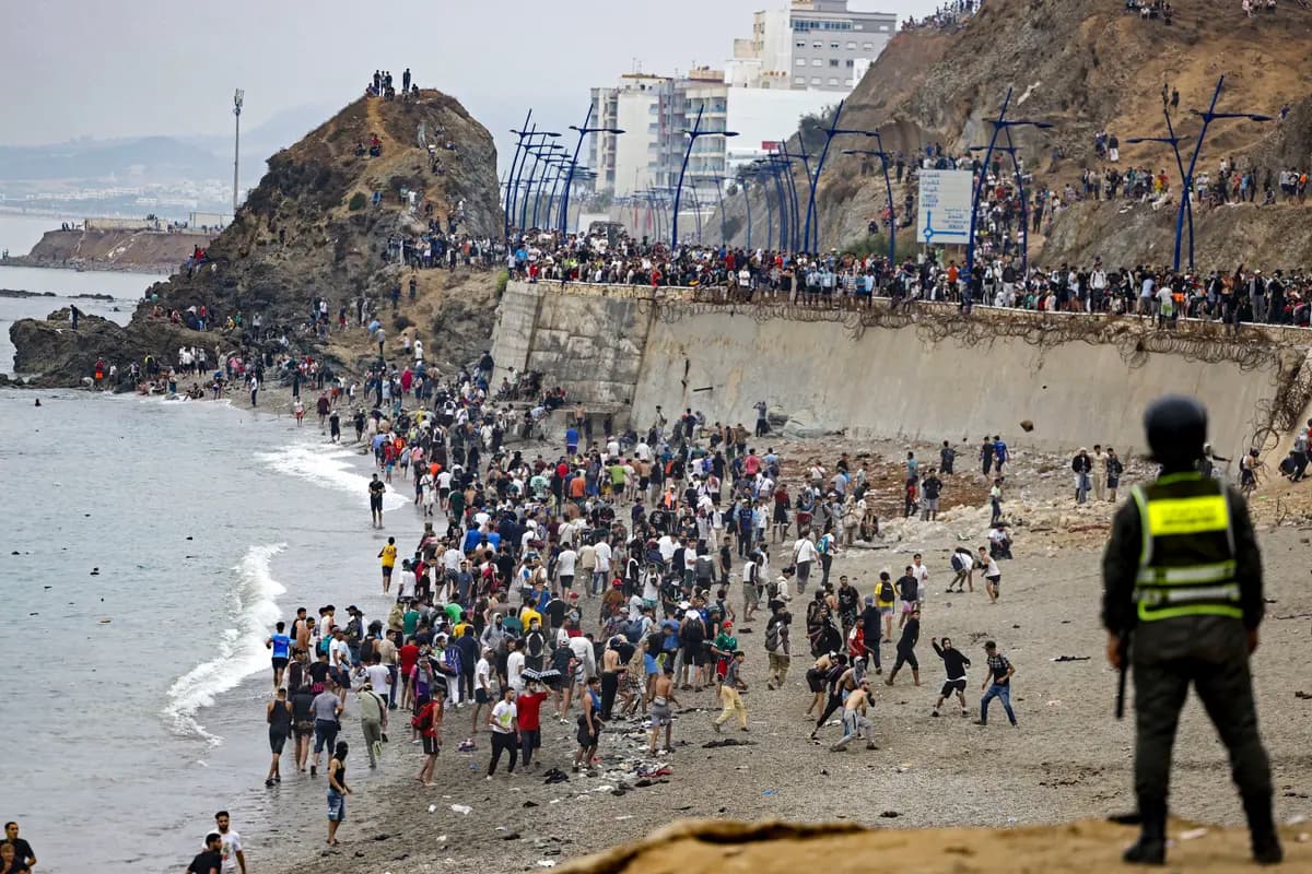 Inmigrantes ilegales se concentran a lo largo de la valla en el lugar de los enfrentamientos cerca de Fnideq, en la frontera entre Marruecos y España, en Fnideq, Marruecos, el 31 de julio de 2026. (Abdel Majid Bziouat/AFP vía Getty Images)
