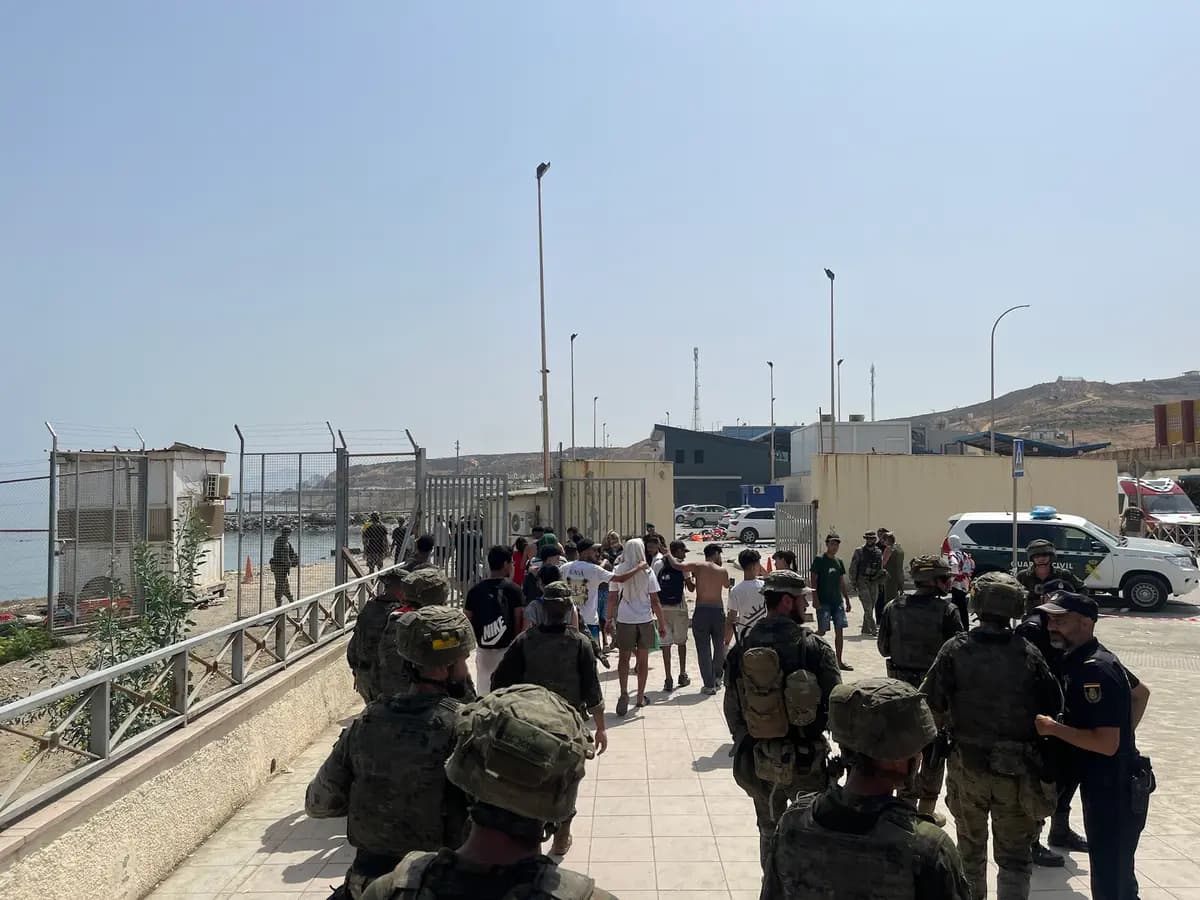 Soldados españoles y agentes de la Guardia Civil escoltan a un grupo de jóvenes migrantes de regreso a Marruecos cerca de la frontera costera en Ceuta, España, el 1 de agosto de 2026. (Etienne Fauchaire para The Epoch Times)