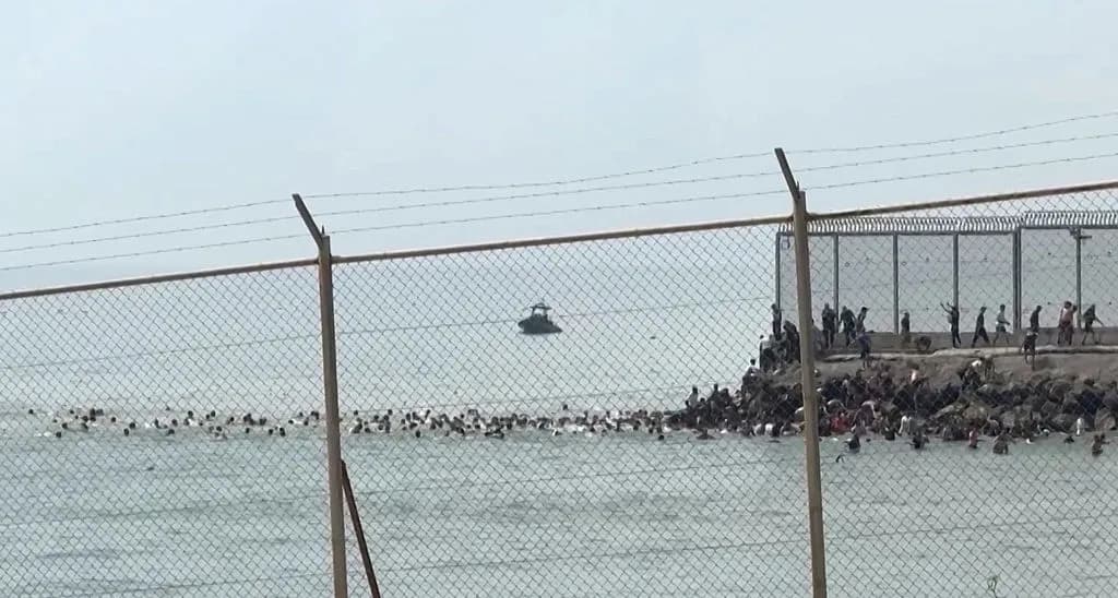 Fotograma obtenido de un vídeo de AFP que muestra a migrantes nadando para alcanzar la costa del enclave español de Ceuta, en el norte de África, el 30 de julio de 2026. Cientos de personas entraron ese día en la ciudad, muchas de ellas bordeando a nado la valla fronteriza. Periodistas de AFP observaron una llegada continua de adultos y niños, la mayoría empapados. La migración desde Marruecos hacia Ceuta y Melilla constituye desde hace años una cuestión políticamente sensible entre ambos países. (Lucía Díaz/AFP vía Getty Images)