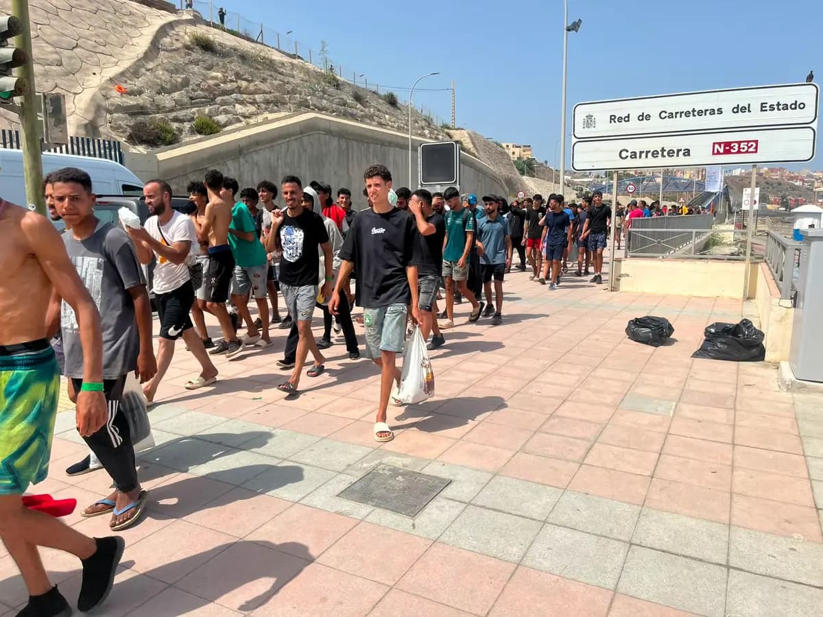 Unos migrantes marroquíes caminan por la carretera N-352, cerca de la frontera en Ceuta, España, el 1 de agosto de 2026, de regreso a Marruecos. (Etienne Fauchaire/The Epoch Times)