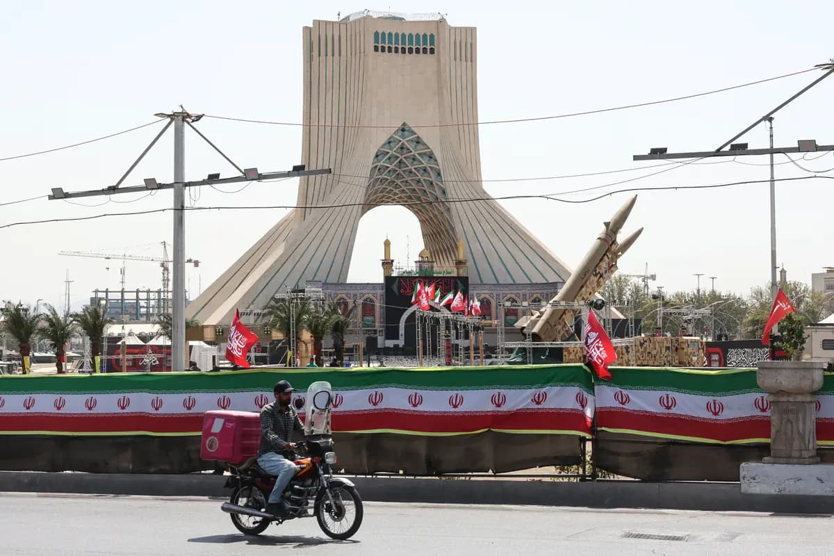 Un hombre pasa en bicicleta junto a misiles de fabricación iraní expuestos en la Plaza Azadi de Teherán el 24 de julio de 2026. (AFP vía Getty Images).