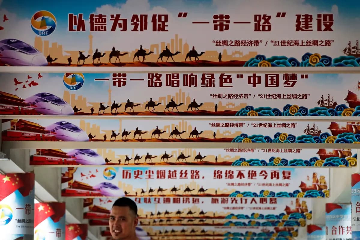 Un hombre se encuentra debajo de los pilares en los que se exhibe el «Sueño Chino» del líder chino Xi Jinping y el plan de política exterior "Un Cinturón, Una Ruta" durante un evento en Beijing el 29 de junio de 2018. (Andy Wong/AP)